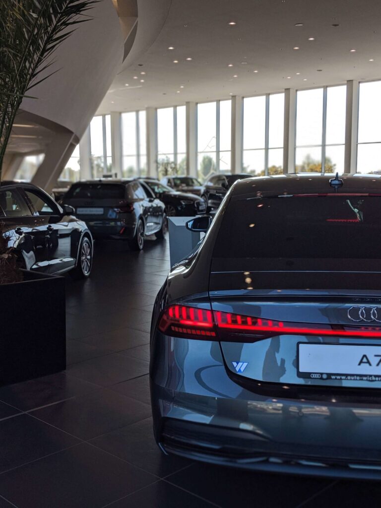 Car dealership lot with various luxury vehicles on display.